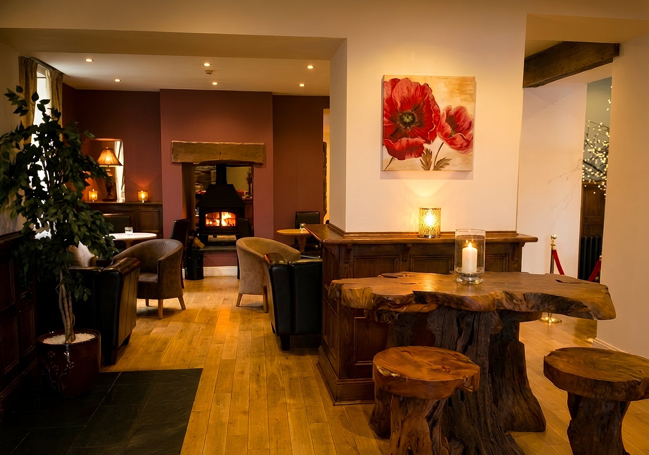 A cozy interior with a wooden bar, seating area, and a fireplace.