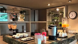 A modern kitchen with a marble countertop, a coffee machine, a blender, and a clock on the wall. - Plaza Inn Express (Tapachula)