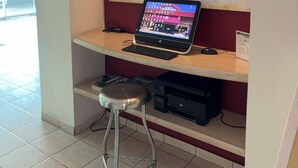A reception desk with a laptop, a world map, and a sign indicating a health and safety policy. - Plaza Inn Express (Tapachula)