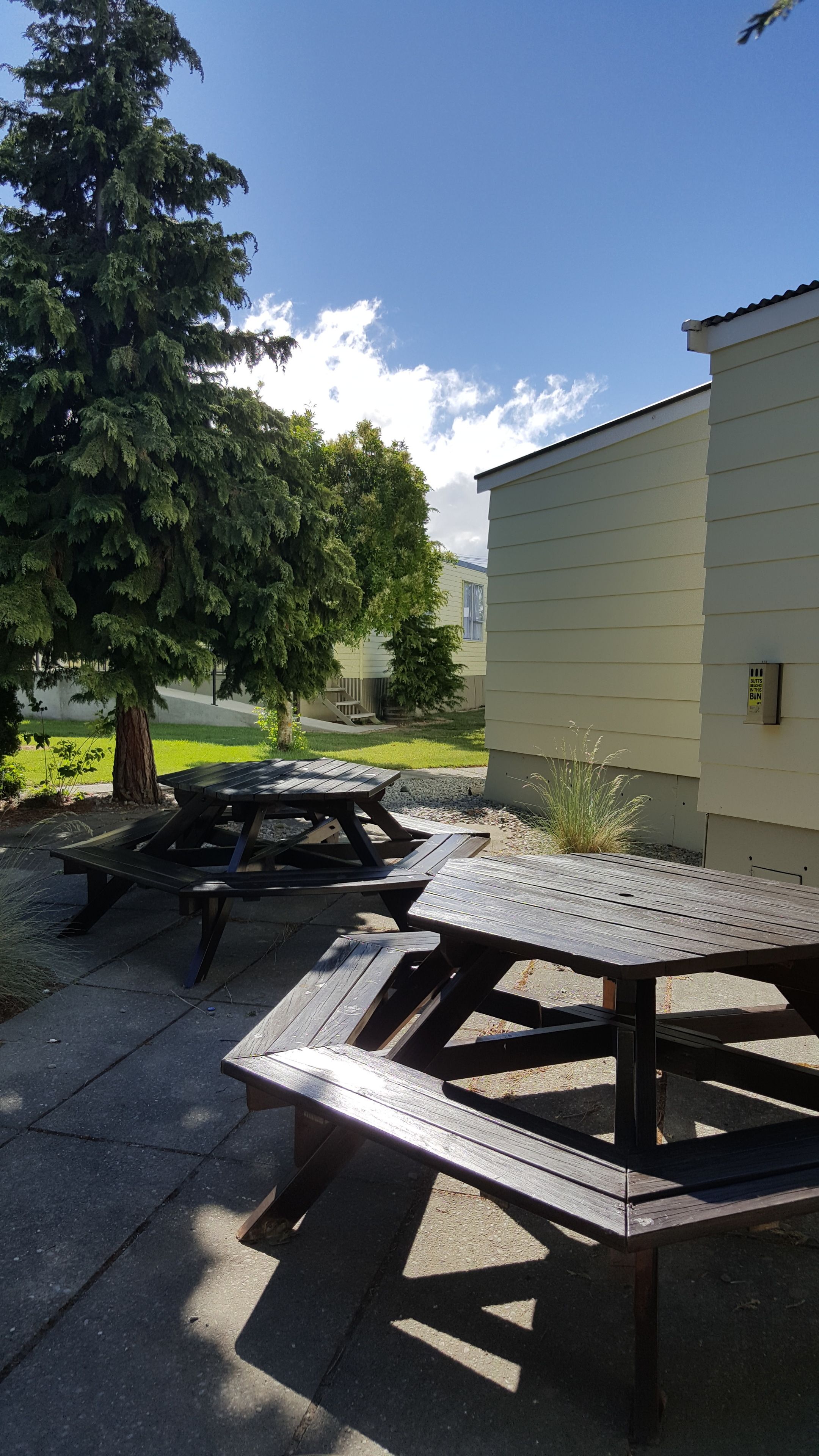 A picnic table set outdoors with a building in the background.