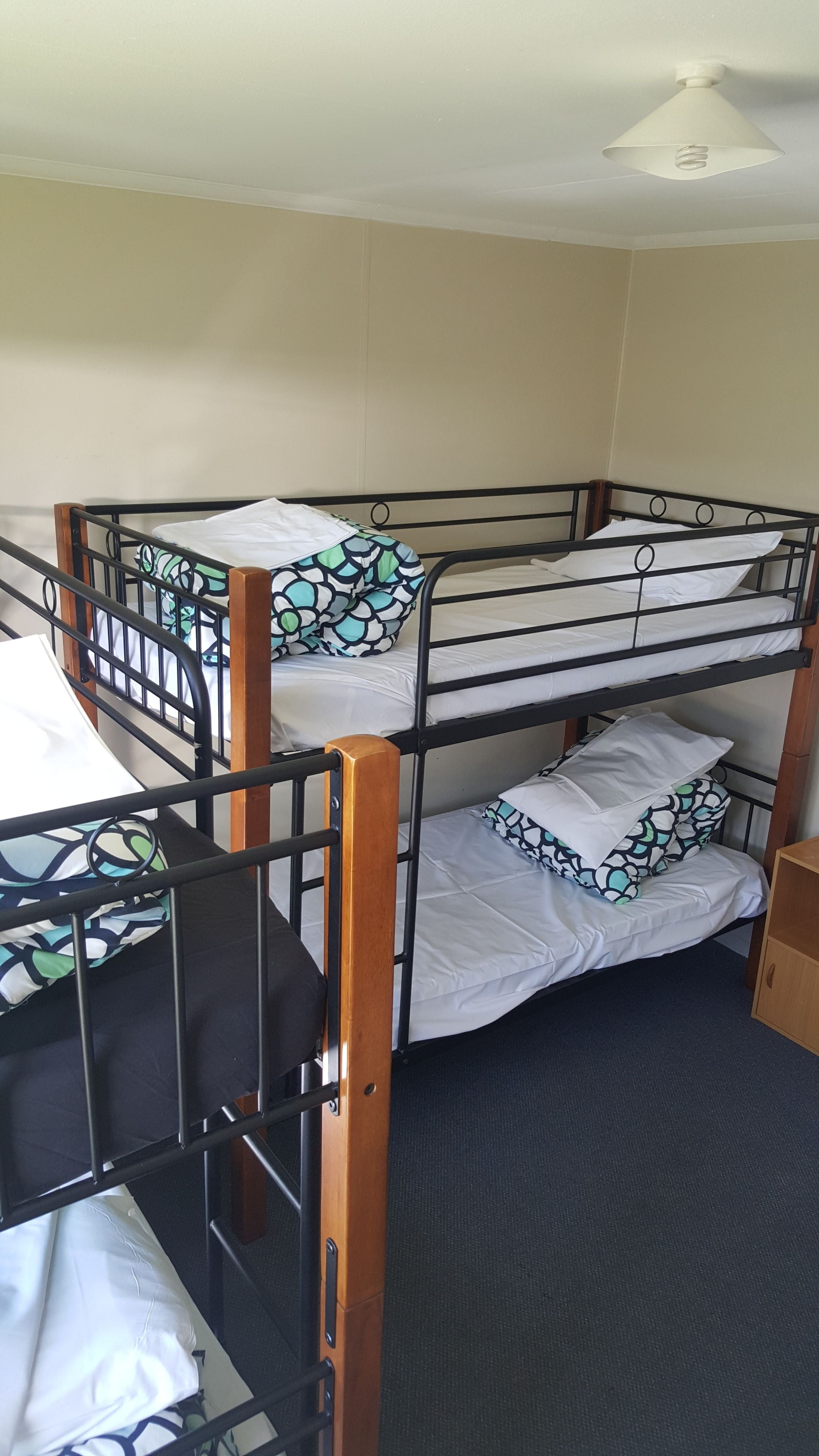 Habitación con literas triples, cada una con colchón y almohada.