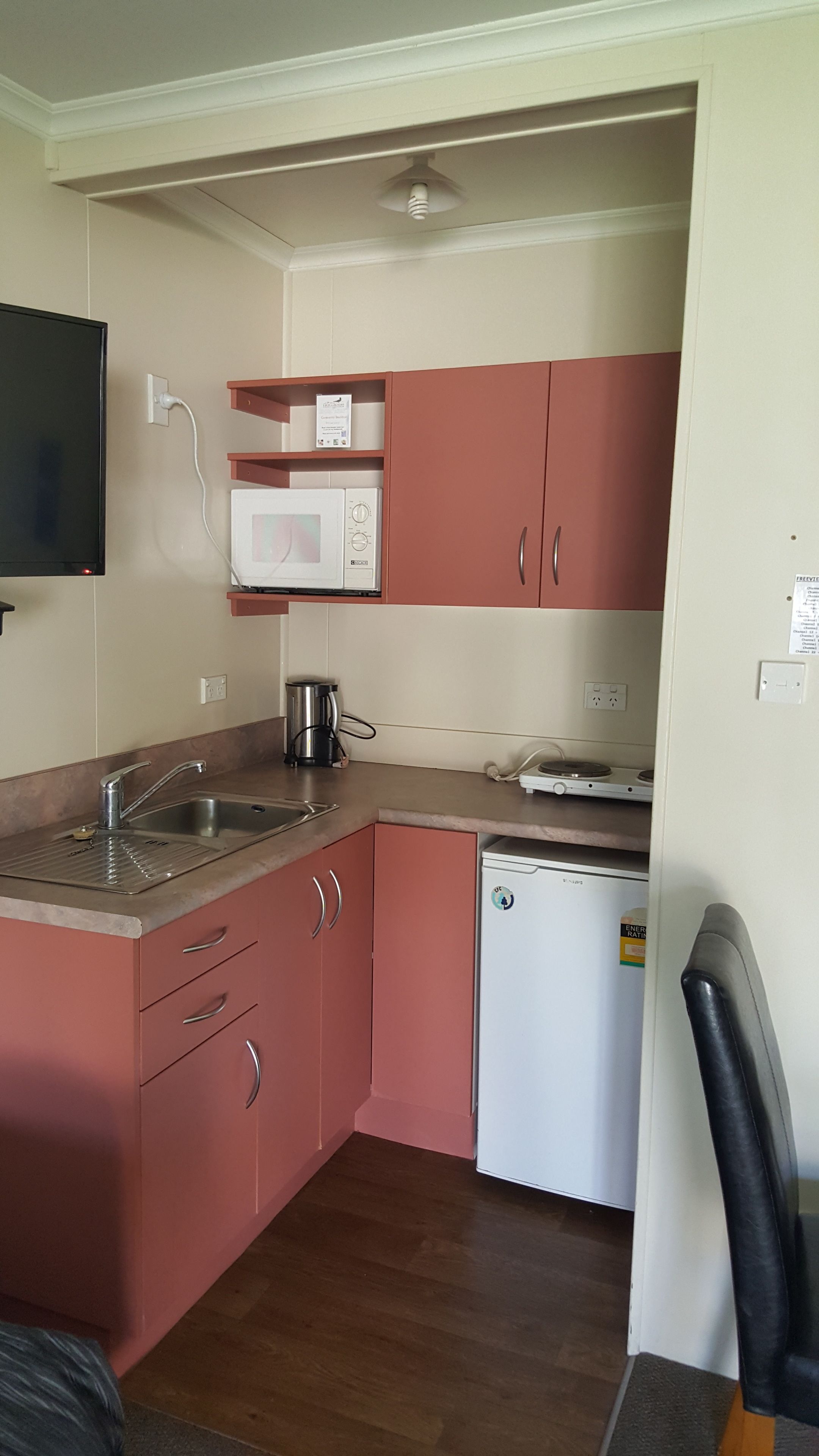 A compact kitchen with a microwave, a coffee maker, and a dishwasher.