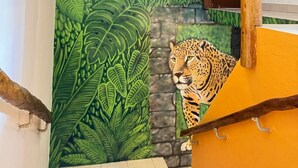 Eine Treppe mit Wandgemälde einer Dschungelansicht, darunter ein Leopard und ein Wasserfall.