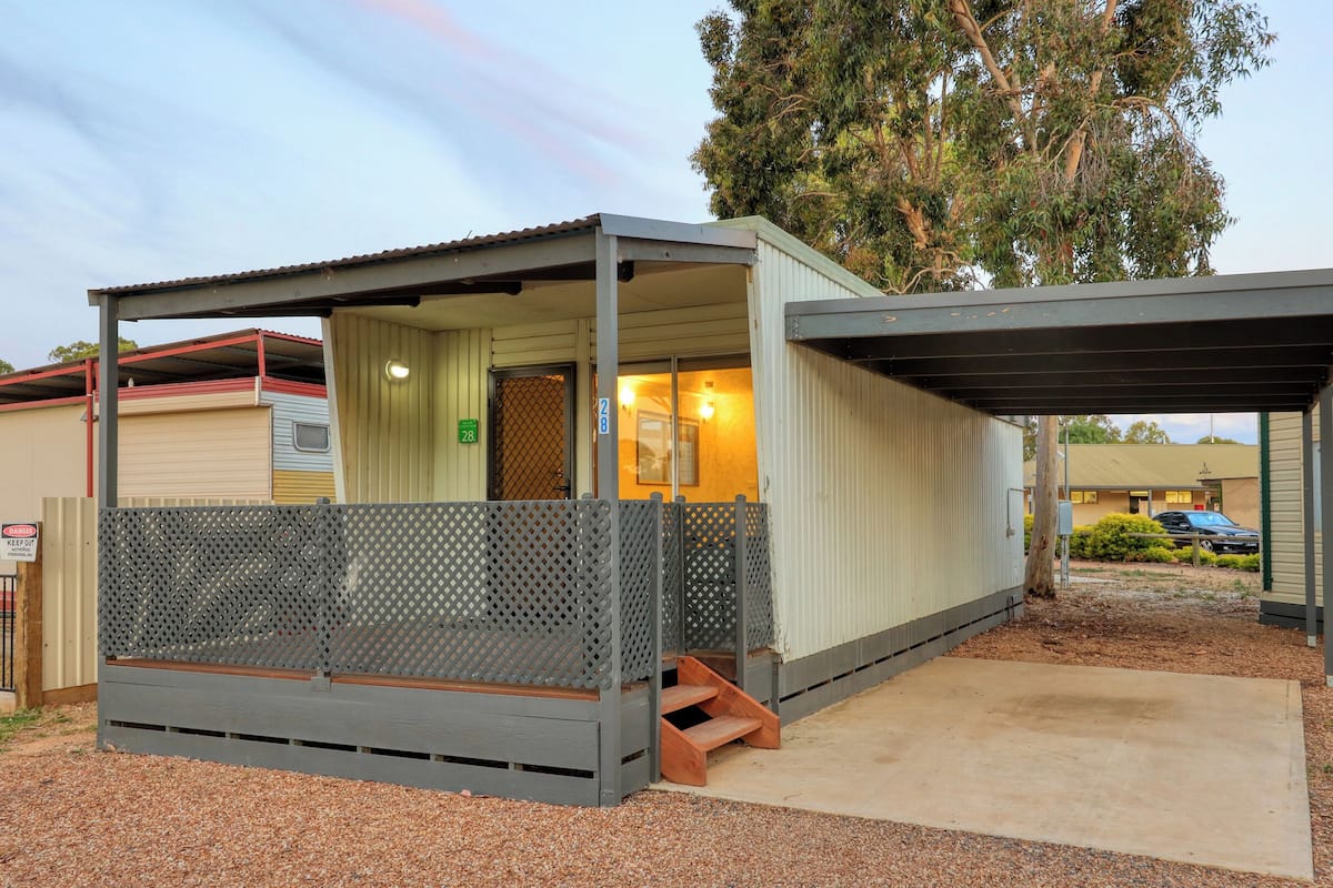 Un petit motel d’un seul étage, doté d’une véranda et d’un espace extérieur clôturé.