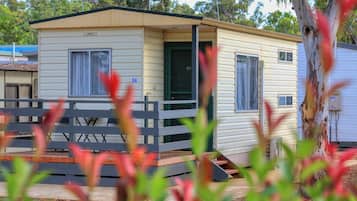 A mobile home with a porch and a small deck, number 36, in a residential area.