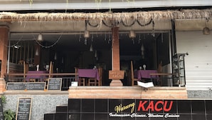 A restaurant with outdoor seating, a thatched roof, and a sign reading "Waring KACU Indonesian, Chinese, Western Cuisine". - Kacu guest house (Ubud)