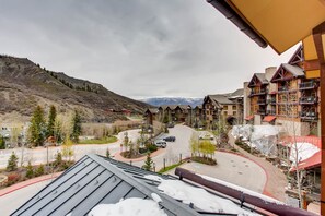 A hotel with a ski resort view, featuring a central roundabout, buildings with balconies, and a mountainous backdrop. - Hayden Lodge by Snowmass Mountain Lodging (Snowmass Village)