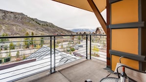 Un balcon donnant sur un paysage montagneux et une zone résidentielle.