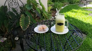A round metal table with a glass pitcher and a plate with food. - Hotel Boutique Valverde Santa Elena (Antiguo Cuscatlán)