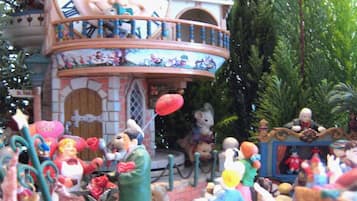 Une scène miniature détaillée comprenant un beffroi, diverses figurines et un petit bâtiment sur lequel on peut lire l’inscription « St. Louis ».