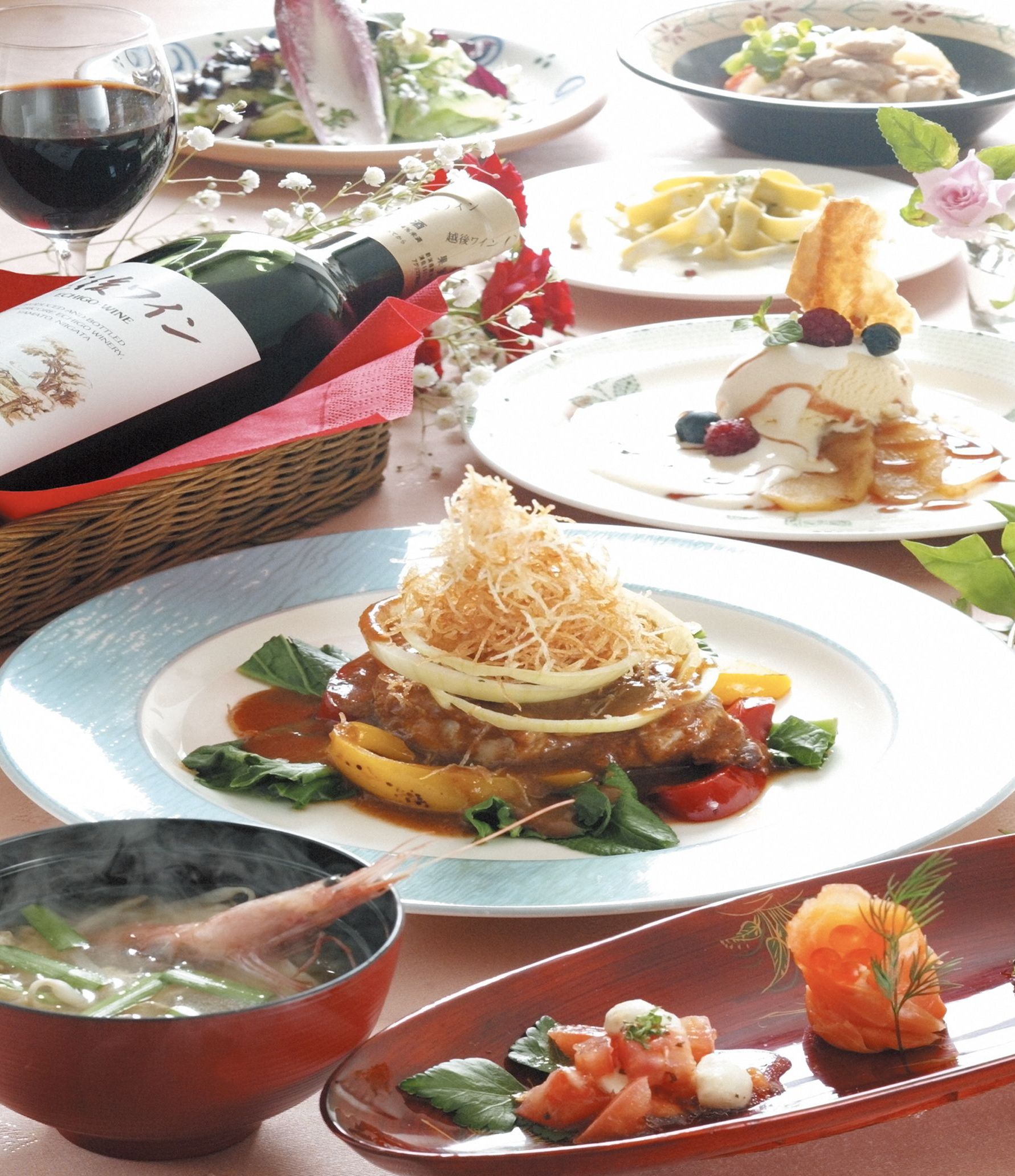 A dining table with various dishes, including a plate with a seafood dish, a bowl of soup, and a bottle of wine.