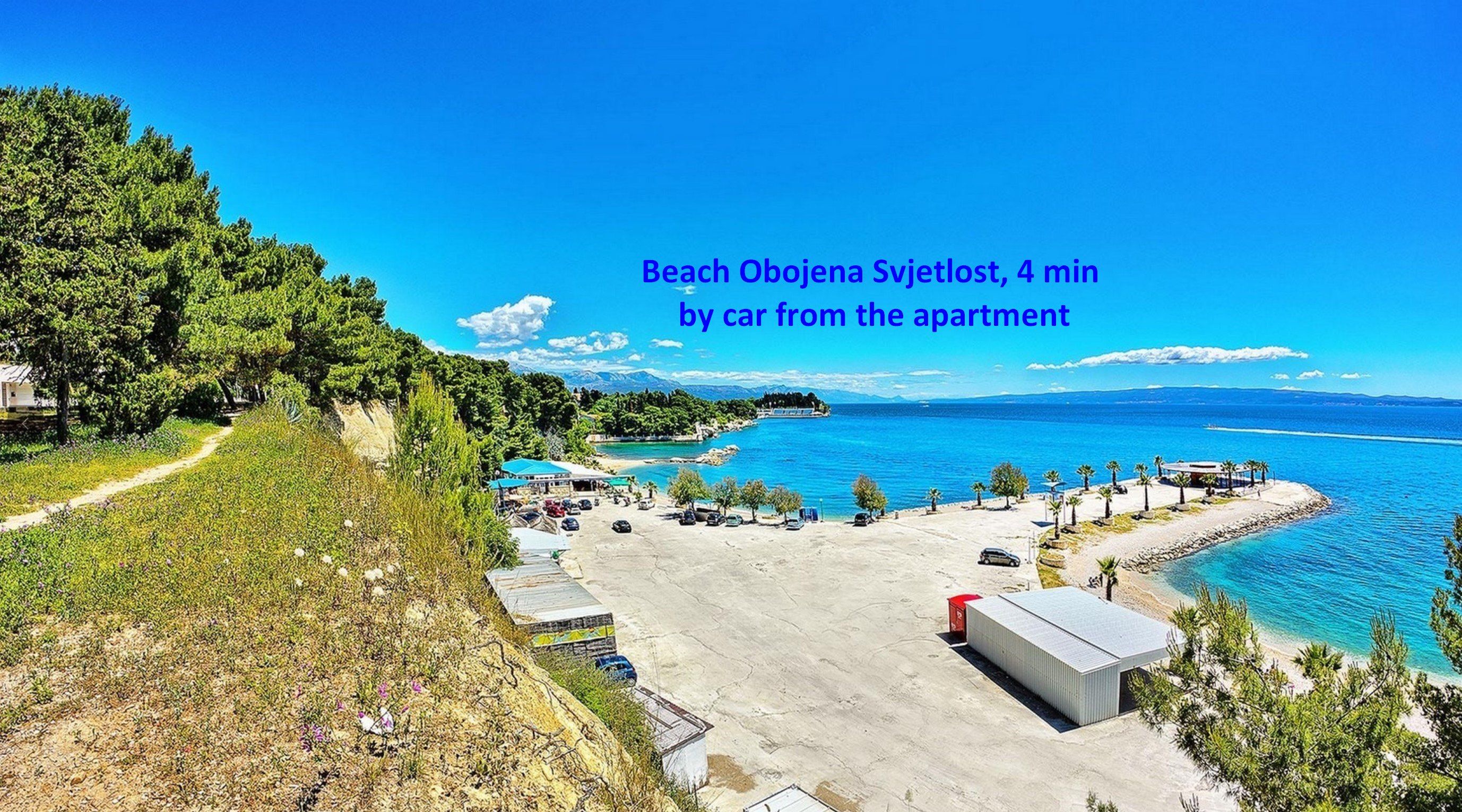 Une plage dotée d’un parking, d’un sentier et offrant une vue sur la mer.