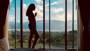 Quarto com uma grande janela com vista para a paisagem.