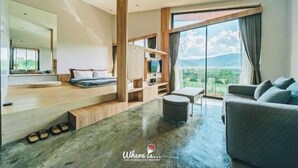 Uma sala de estar moderna com uma janela grande, um sofá, uma mesa de centro e uma televisão.