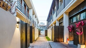 Un estrecho sendero pavimentado bordeado por edificios con balcones e iluminación exterior.