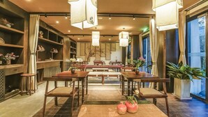 Habitación tradicional japonesa con mobiliario de madera, suelo de tatami y vistas al exterior.