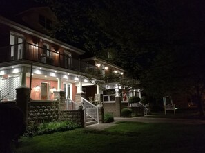 Une maison à deux étages dotée d’un balcon, d’un pilier en pierre et d’une entrée bien éclairée.