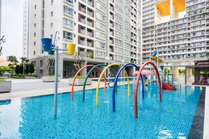 A swimming pool with colorful arches and a modern building in the background.