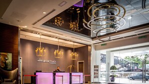 A modern hotel reception with a check-in counter, a seating area, and a view of the street outside. - D'Majestic Place by Widebed (Kuala Lumpur)