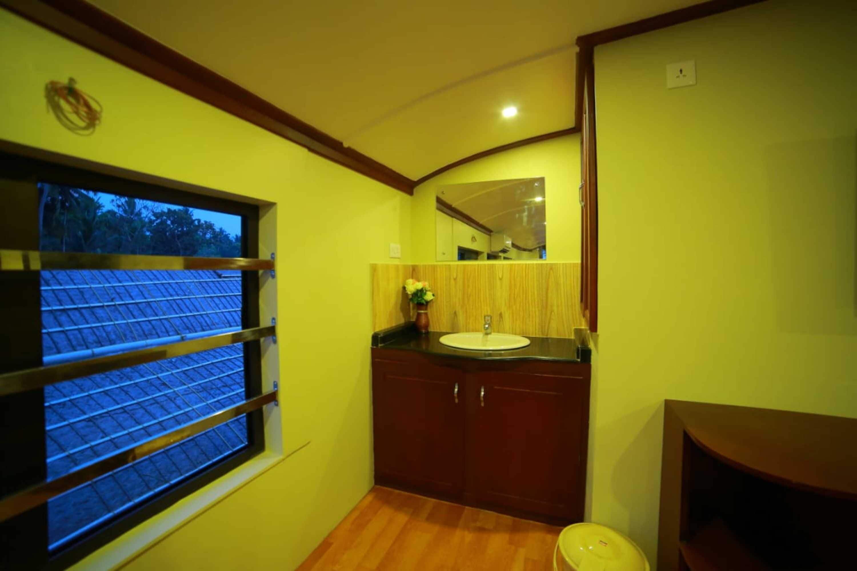 A bathroom with a window, wooden cabinets, a sink, and a mirror.