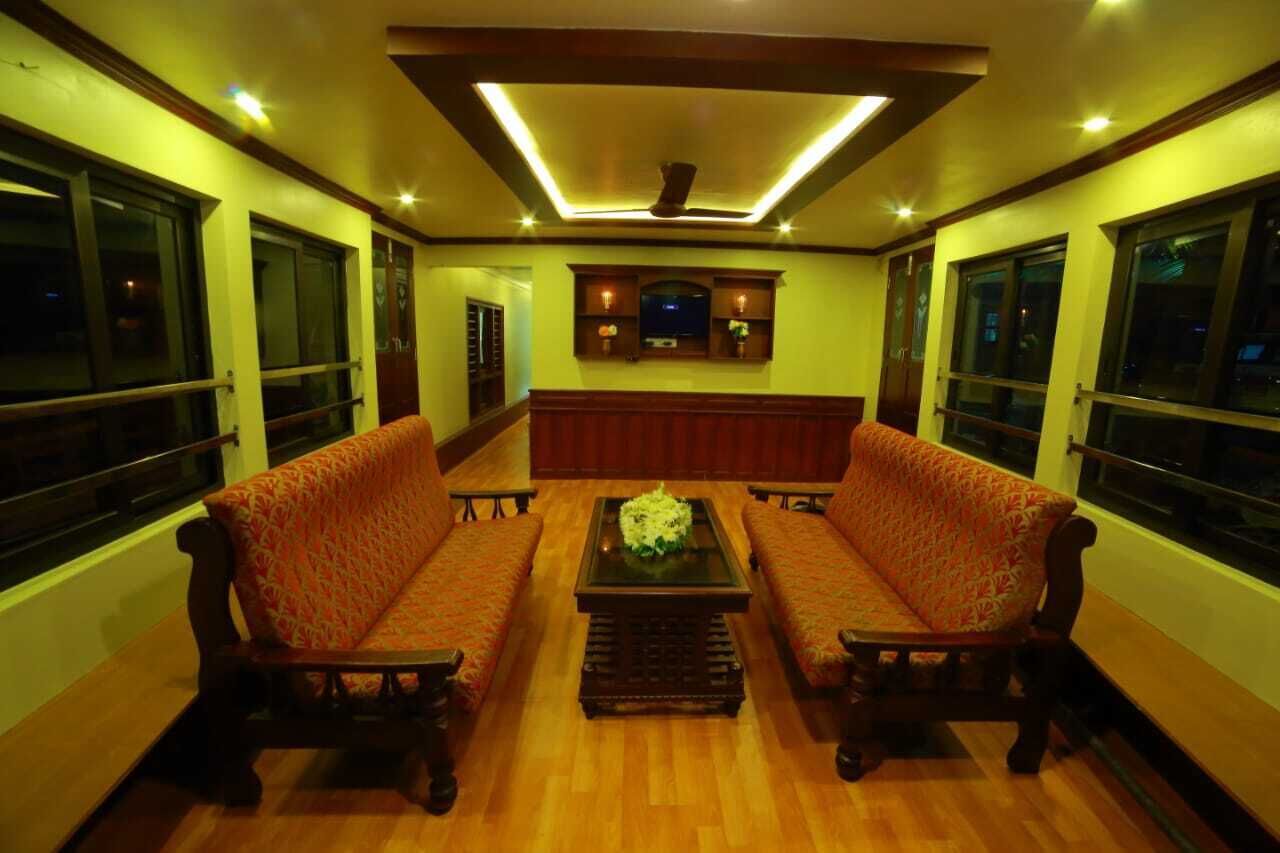 Quarto com sofá, mesa de centro e luminária no teto.