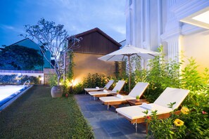 Piscine extérieure, parasols de plage, chaises longues
