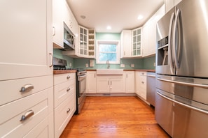 Enjoy cooking in this well-equipped kitchen with a microwave, oven, and refrigerator.