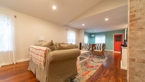A living room with a sofa, a coffee table, and a patterned rug. - Walking Distance to Shops, Beach, Restaurants and Brewery  (New Buffalo)