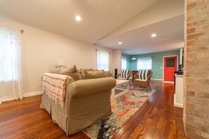 Relax in this inviting living space with a comfortable sofa, coffee table, and wicker chair.