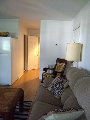 A living room with a sofa, a chair, a table, a lamp, and a refrigerator. - Very clean & private (Bowling Green)