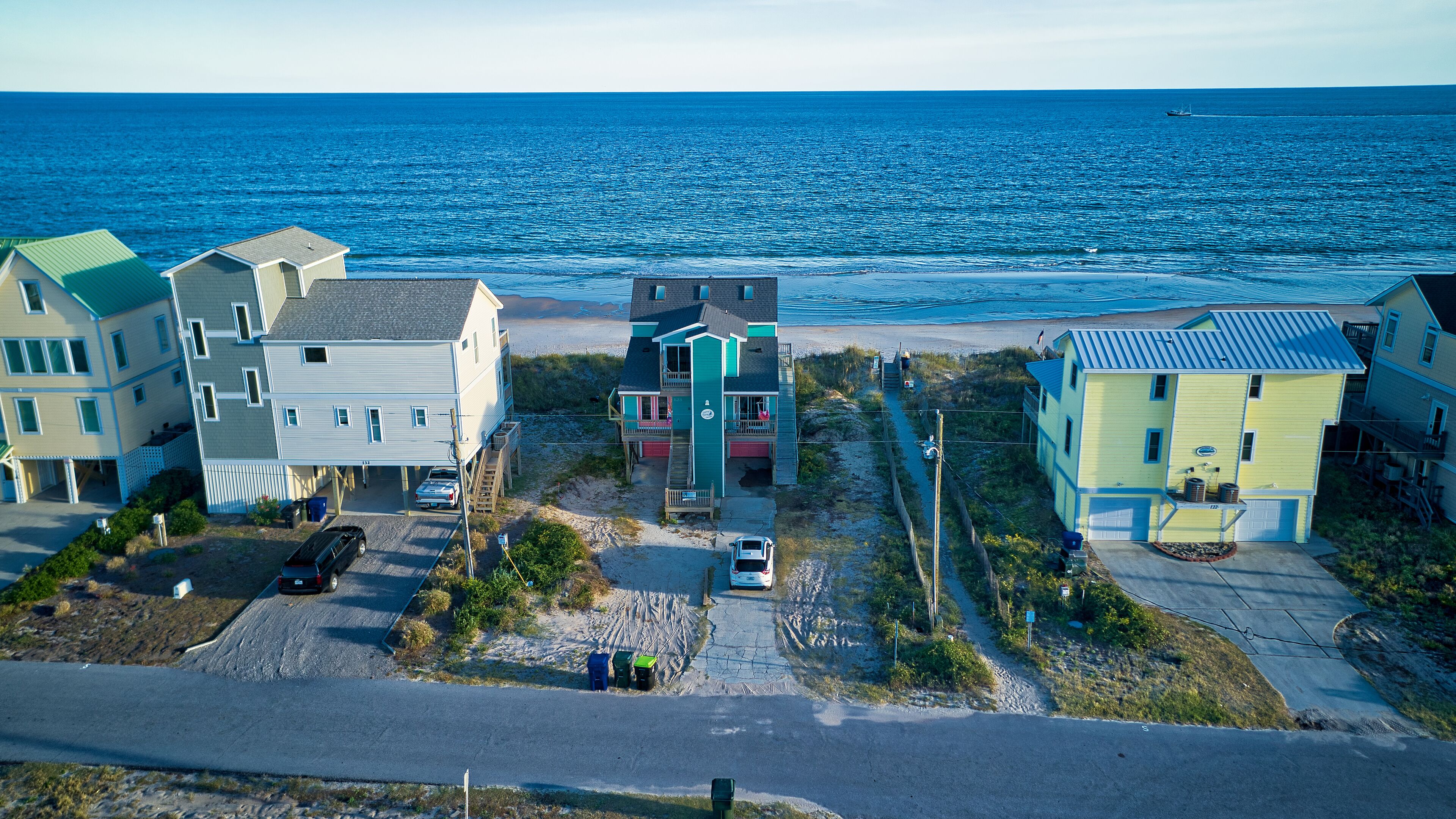 A coastal residential area with houses, a beach, and the ocean.