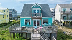 A two-story house with a balcony, a deck, and a small porch area.