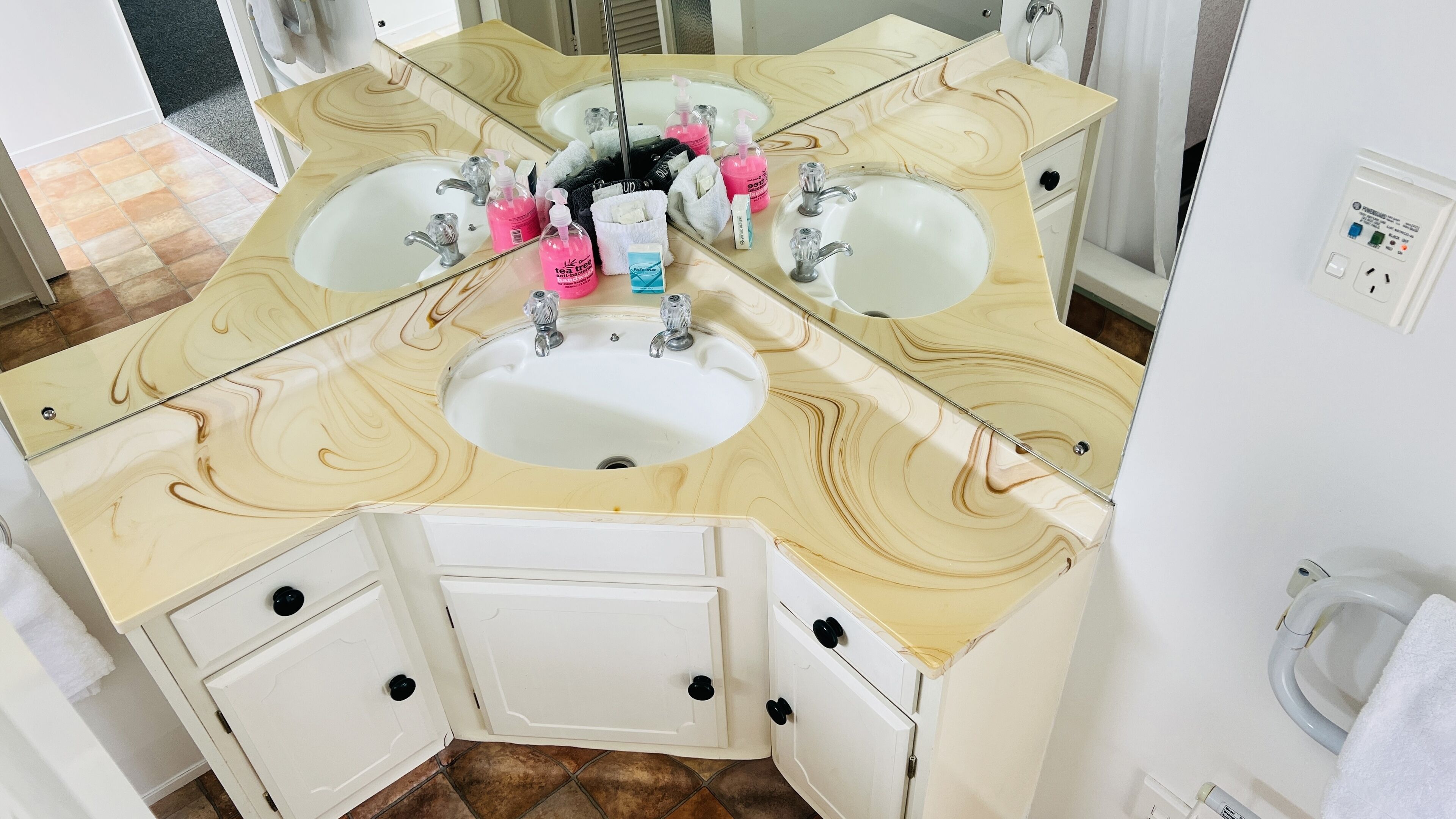 A bathroom with a marble vanity, two sinks, and a large mirror.