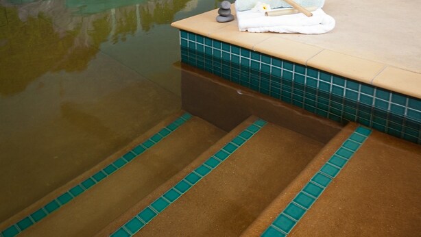 Un área de spa con piscina, una toalla y una silla de masaje.