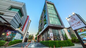 A modern hotel with a glass facade, a sign for 'OH CHIC' on the right, and a 'CIVIC Hotel & Residence' sign on the left.