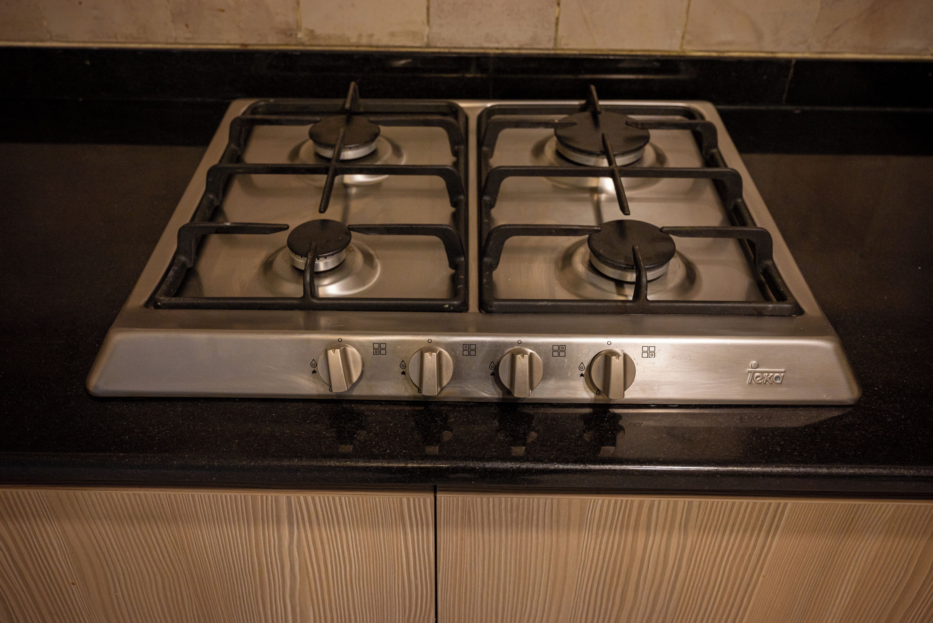 Een gasfornuis met vier branders, knoppen en een merklogo.