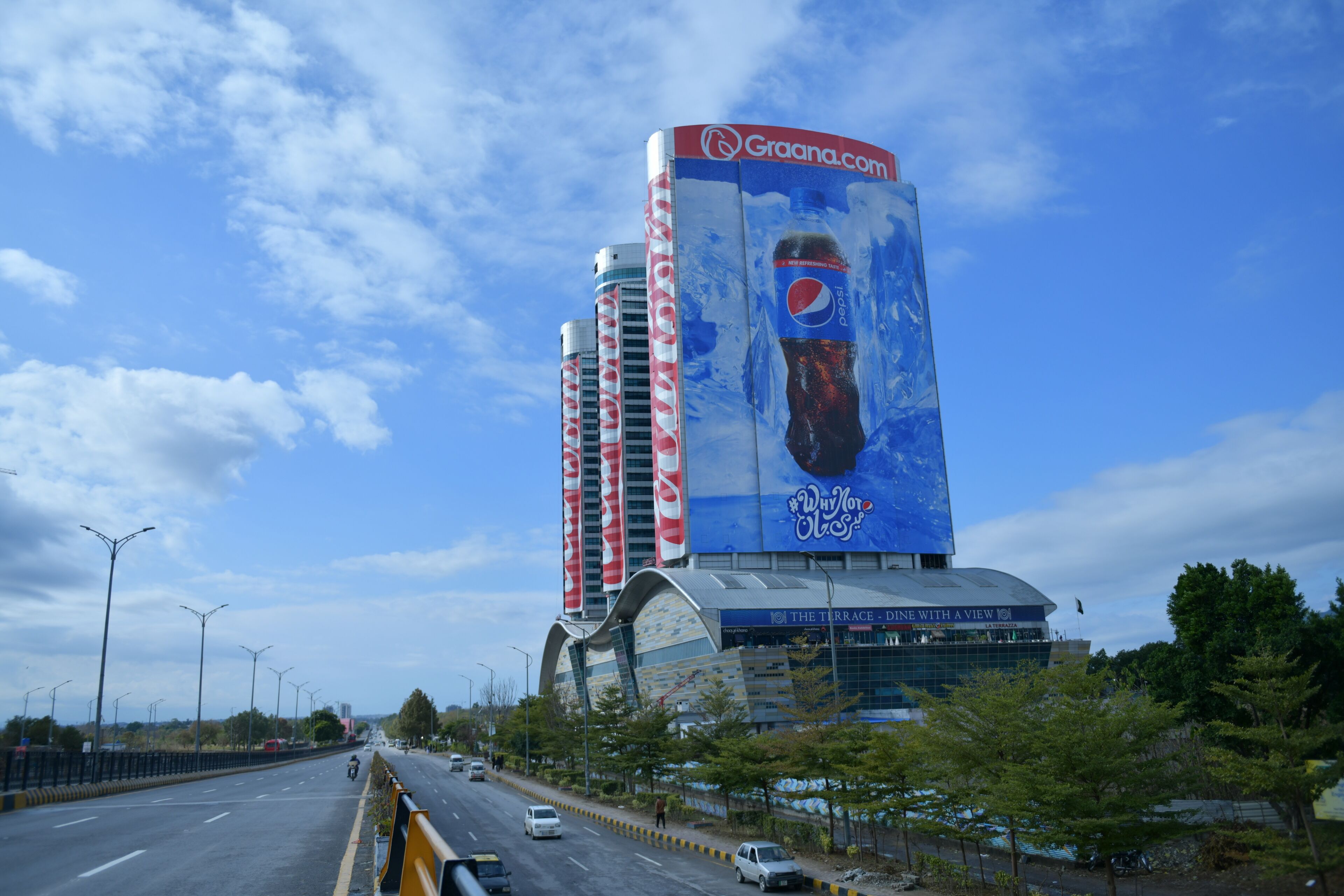 Un grand bâtiment orné d’une publicité Pepsi bien visible, doté d’une architecture moderne et offrant une vue sur les environs.