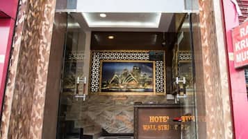A hotel entrance with a checkered floor, a framed artwork above the door, and a sign reading "HOTEL WALT STREET 2".