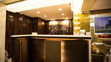 A reception area with a cityscape view, a reception desk, and a seating area with a view of the city.