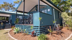 A blue building with a covered porch and a small garden area with various plants. - Jacobs Well Tourist Park (Jacobs Well)