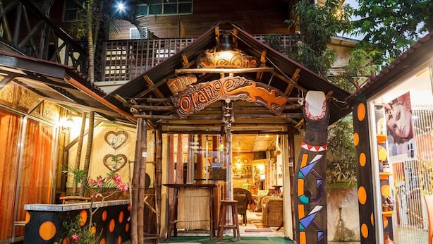 A wooden structure with a sign reading 'The Orchid,' surrounded by tropical plants and a decorative fence. - Lala Panzi (Puerto Princesa)