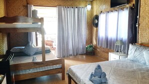 A room with a bunk bed, a single bed, a television mounted on the wall, and a ceiling fan. - Lala Panzi (Puerto Princesa)