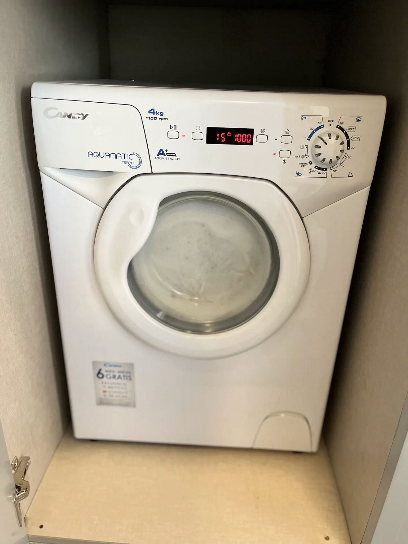 En tvättmaskin av märket Candy, modell Aquamatic, med frontmatning, 4 kg kapacitet, digital display, kontrollpanel och ett filter med 6 filtersteg.