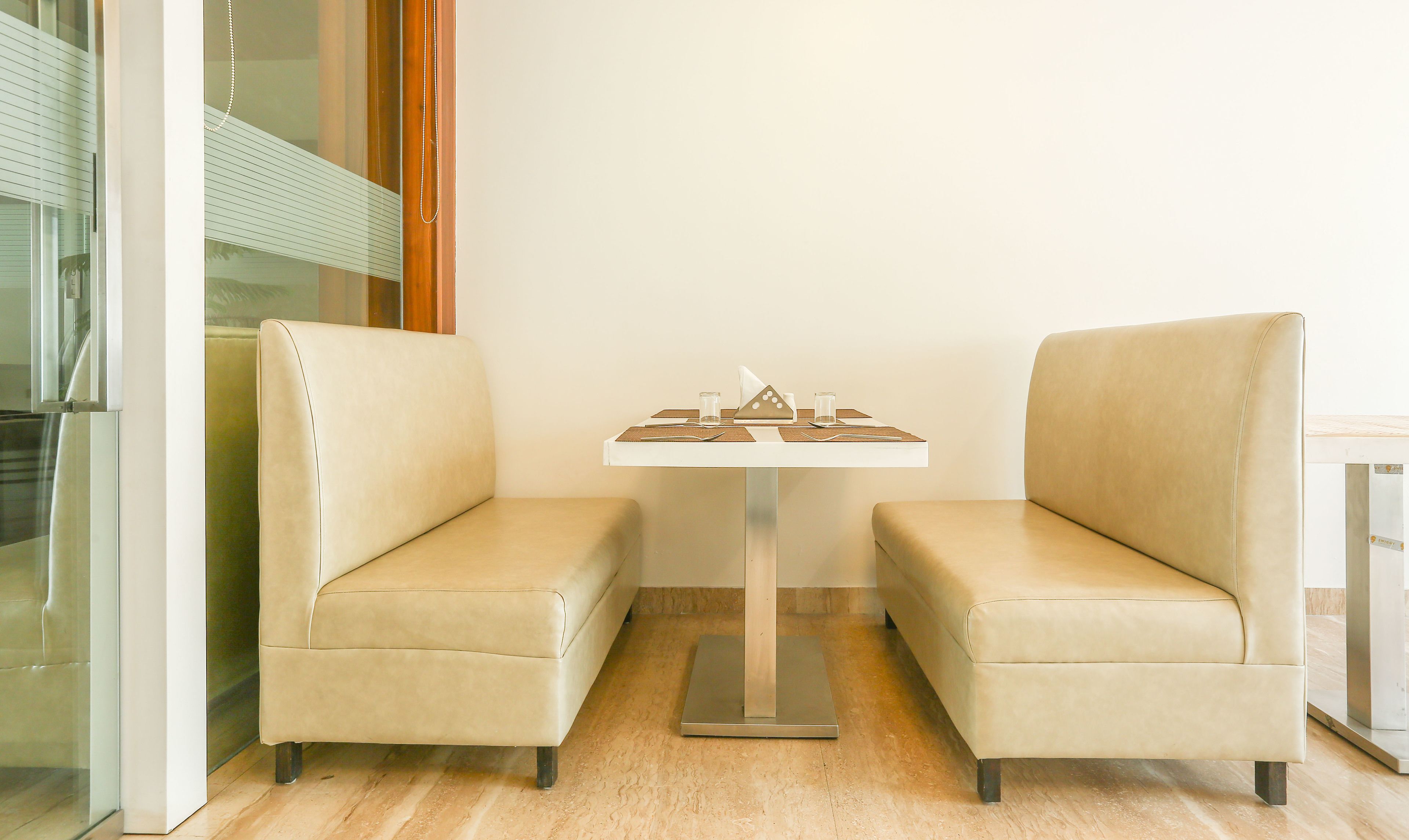 A corner seating area with two cushioned chairs and a small table with a decorative object.
