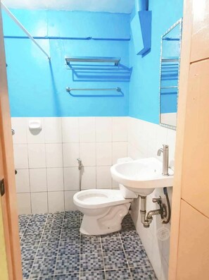Une petite salle de bain avec des toilettes, un lavabo et des murs bleus.