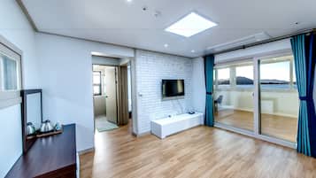 Quarto famรญlia, vista para o oceano | Sala de estar | TV de tela plana