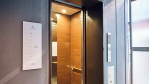Un ascensor con interior de madera y un directorio montado en la pared.