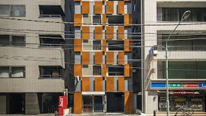 Un edificio moderno con una fachada singular que presenta patrones alternados de ventanas y paneles sólidos.