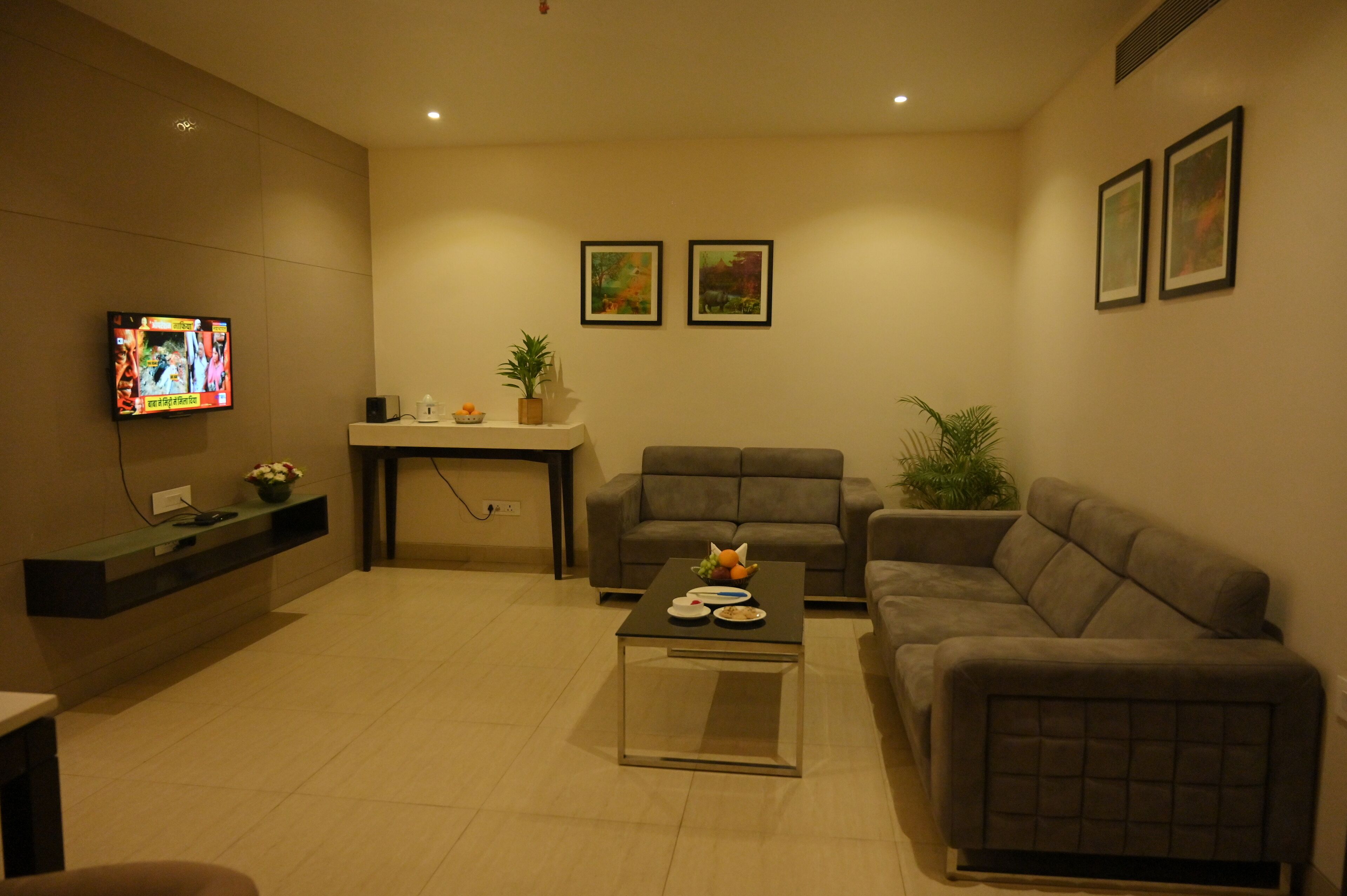 A modern living room with a sofa, a coffee table, and a TV mounted on the wall.