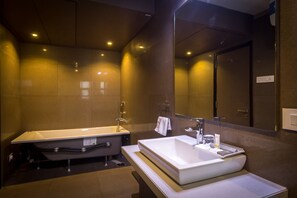 A modern bathroom with a freestanding bathtub, a large sink, and a mirror above the sink. - Hotel Palacio (Guwahati)